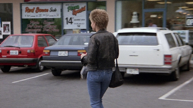 Frame from The Accused — walking, street, car