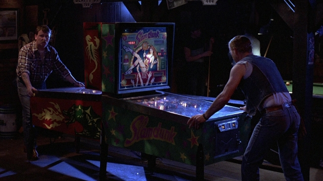 Wide shot frame from The Accused — standing, room, table