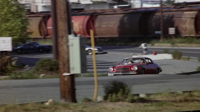 Wide shot frame from The Accused — walking, street, car
