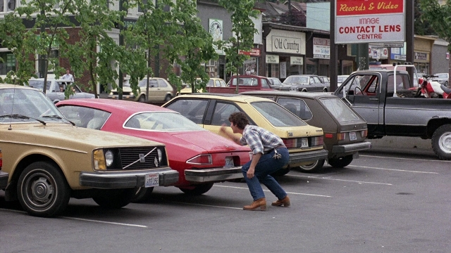 Frame from The Accused — street, car, shirt