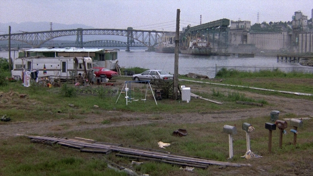 Wide shot frame from The Accused — boat, land vehicle