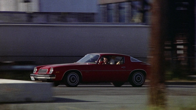 Wide shot frame from The Accused — street, car, wheel