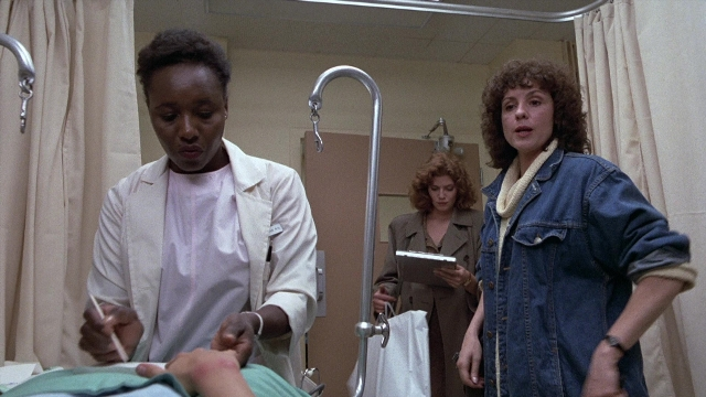 Wide shot frame from The Accused — room, bed, coat