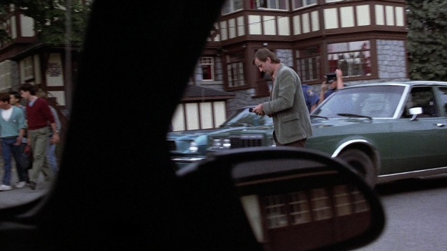 Wide shot frame from The Accused — standing, walking, street