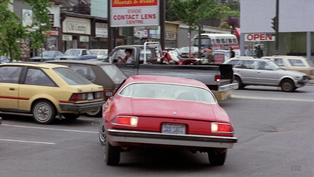 Frame from The Accused — plate, street, car