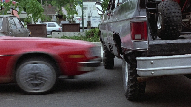 Wide shot frame from The Accused — street, car, truck
