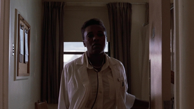 Frame from The Accused — standing, door, shirt