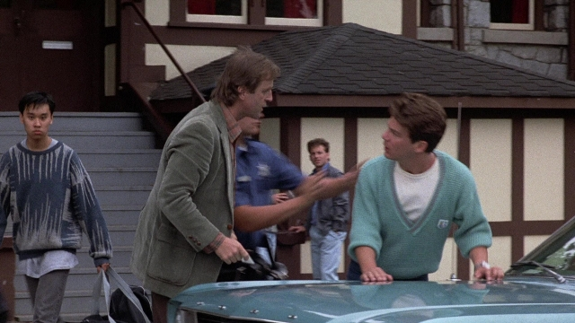 Wide shot frame from The Accused — standing, car, hand