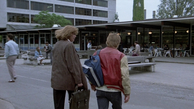 Wide shot frame from The Accused — sitting, walking, street