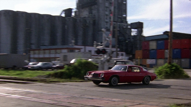 Wide shot frame from The Accused — street, car, wheel