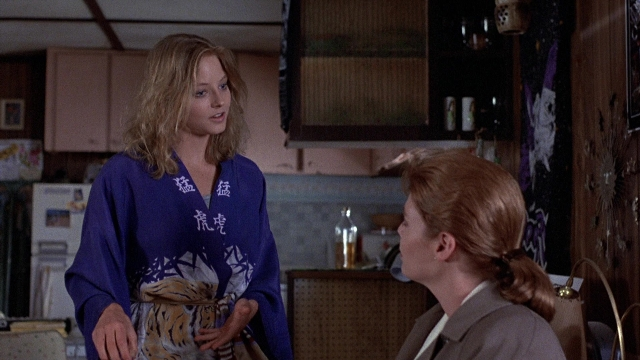 Wide shot frame from The Accused — dialogue, kitchen, face
