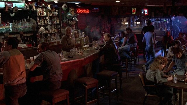 Wide shot frame from The Accused — sitting, standing, table