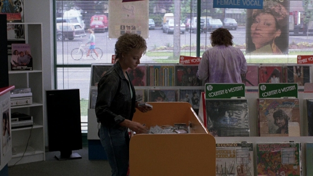 Wide shot frame from The Accused — standing, bookcase, person