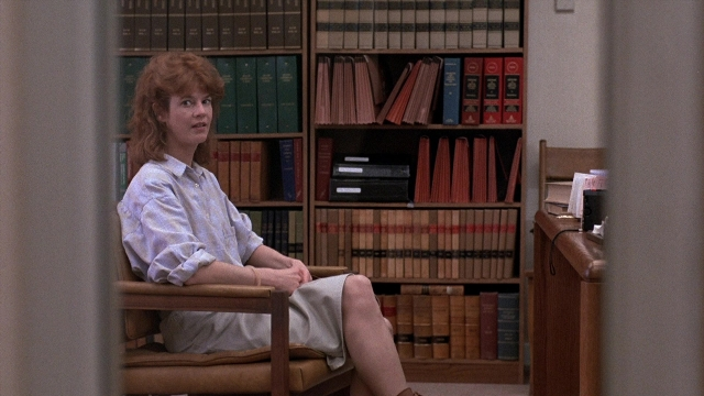Wide shot frame from The Accused — sitting, book, room