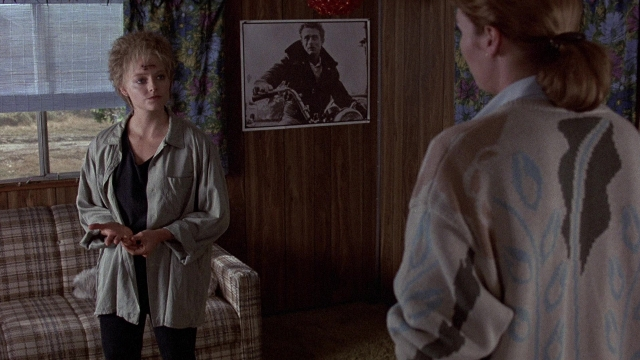Wide shot frame from The Accused — standing, room, coat