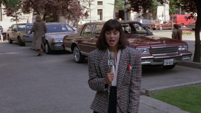 Wide shot frame from The Accused — standing, dialogue, street