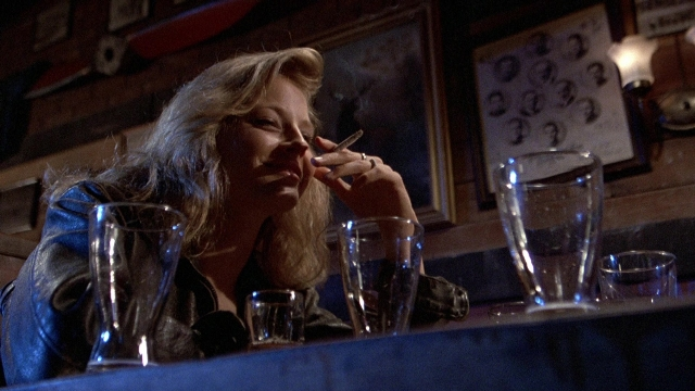 Medium shot frame from The Accused — sitting, table, hand