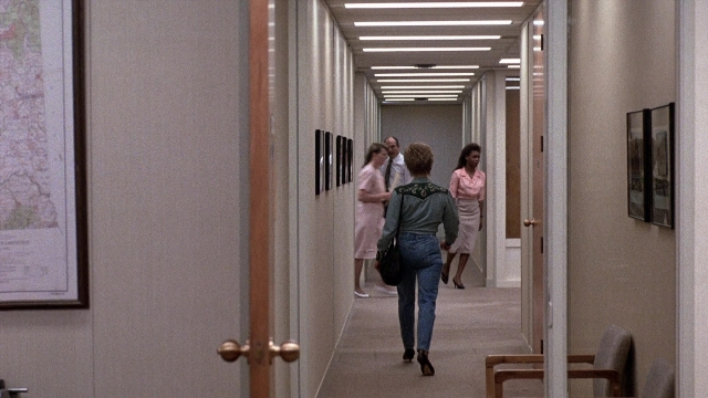 Wide shot frame from The Accused — walking, door, shirt