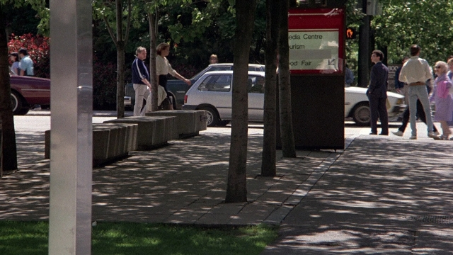 Wide shot frame from The Accused — walking, street, car