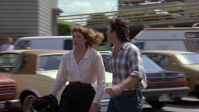 Wide shot frame from The Accused — walking, street, car