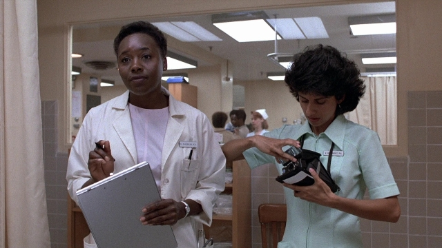 Wide shot frame from The Accused — room, mirror, coat