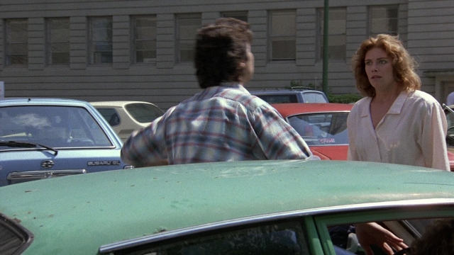 Wide shot frame from The Accused — standing, car, shirt
