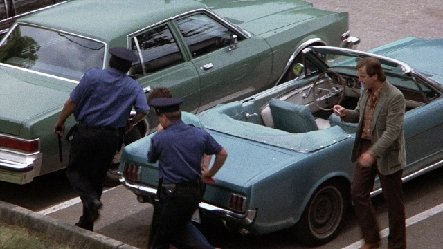 Frame from The Accused — walking, street, car