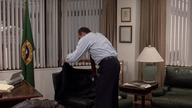 Wide shot frame from The Accused — room, table, house
