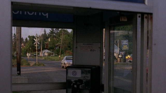 Wide shot frame from The Accused — phone, door, street