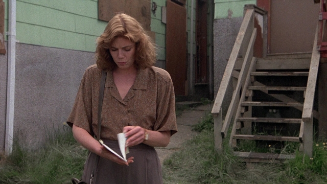Wide shot frame from The Accused — book, standing, door