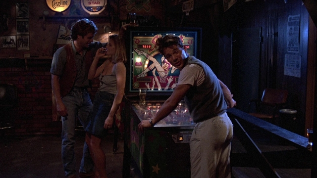 Wide shot frame from The Accused — standing, room, table