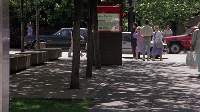 Wide shot frame from The Accused — walking, street, car