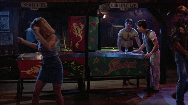 Wide shot frame from The Accused — standing, room, table