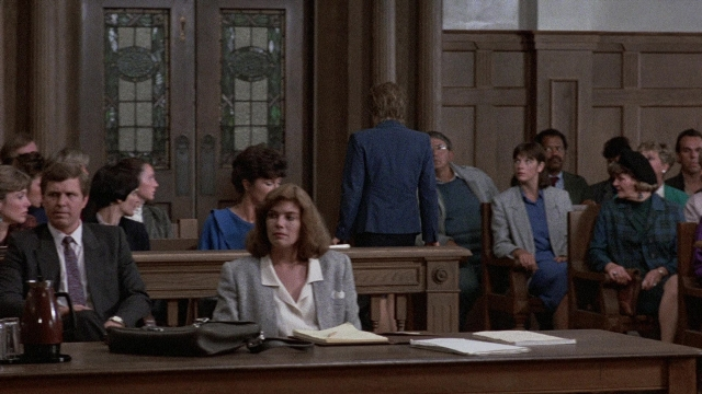 Wide shot frame from The Accused — sitting, standing, room