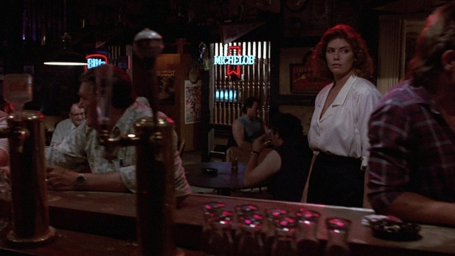 Wide shot frame from The Accused — sitting, standing, table