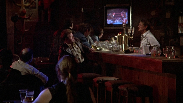 Wide shot frame from The Accused — sitting, standing, person