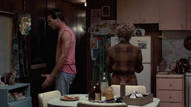 Wide shot frame from The Accused — standing, plate, table
