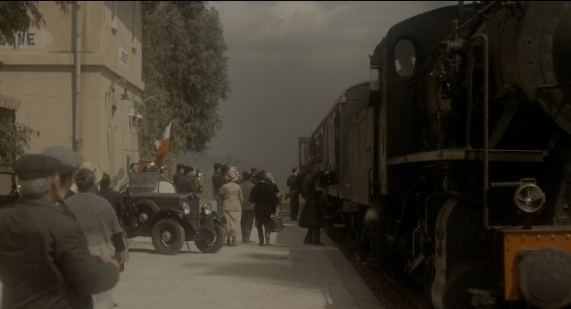 Wide shot frame from The Godfather: Part II — street, train, wheel