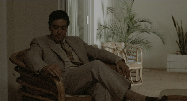 Wide shot frame from The Godfather: Part II — sitting, room, suit