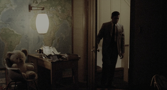Wide shot frame from The Godfather: Part II — standing, room, table