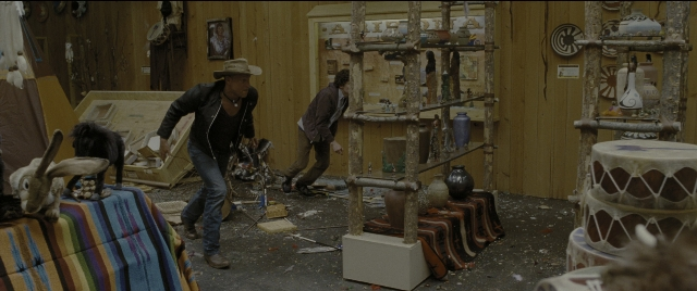 Wide shot frame from Zombieland — walking, room, table