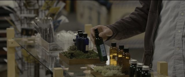 Wide shot frame from Zombieland — standing, hand, bottle