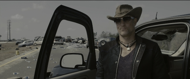 Medium shot frame from Zombieland — standing, mirror, hat