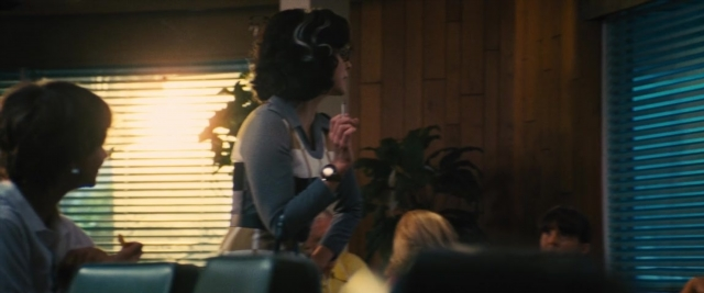 Wide shot frame from Battle of the Sexes — sitting, standing, room