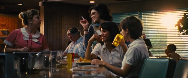 Wide shot frame from Battle of the Sexes — sitting, table, dialogue