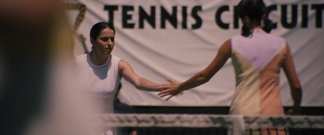 Wide shot frame from Battle of the Sexes — standing, dress, face
