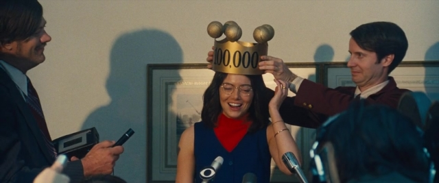 Wide shot frame from Battle of the Sexes — standing, dialogue, suit