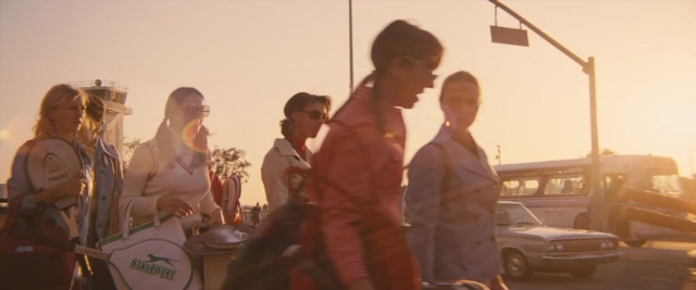 Wide shot frame from Battle of the Sexes — walking, street, car