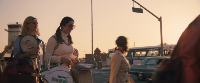 Wide shot frame from Battle of the Sexes — walking, street, car