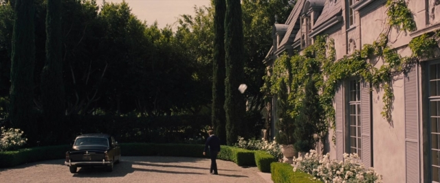 Wide shot frame from Battle of the Sexes — walking, car, house
